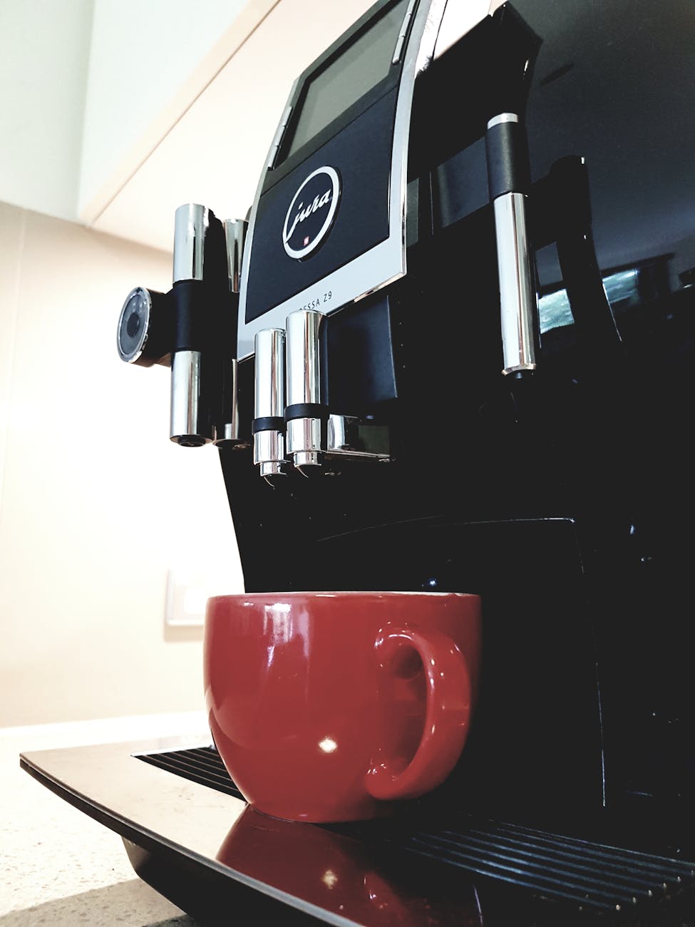 black coffeemaker with red ceramic teacup