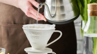 photo of person pouring water on a cup